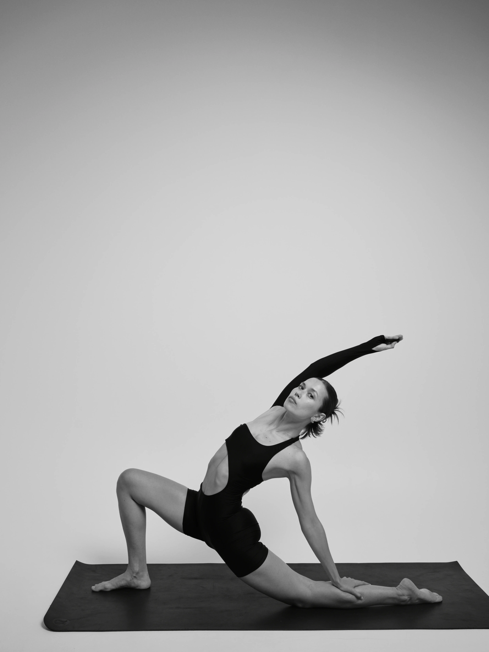 a woman in a yoga pose on a mat, white background